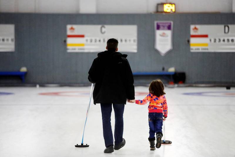 Far og datter som flyktet fra Syria. Her leier de på curlingbanen i Toronto.