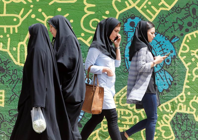 Bildet viser kvinner kledd i hijab som snakker i telefonen. To andre kvinner i heldekkende plagg går andre veien.