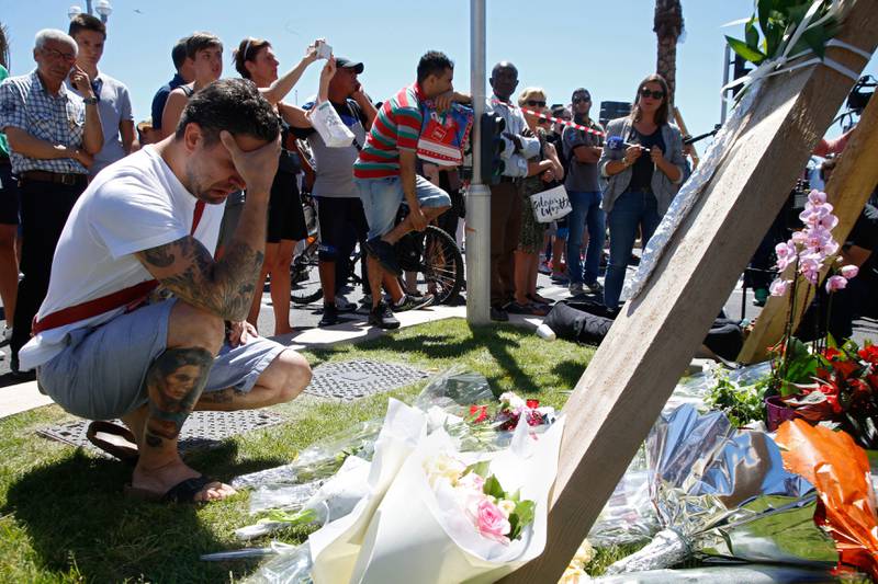 Bildet viser en mann i Nice som tar seg til ansiktet. Han sørger etter terrorangrepet i byen.