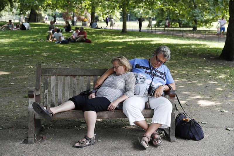 Bildet viser et par som slapper av i skyggen i St James's Park i London i Storbritannia 21. juni.