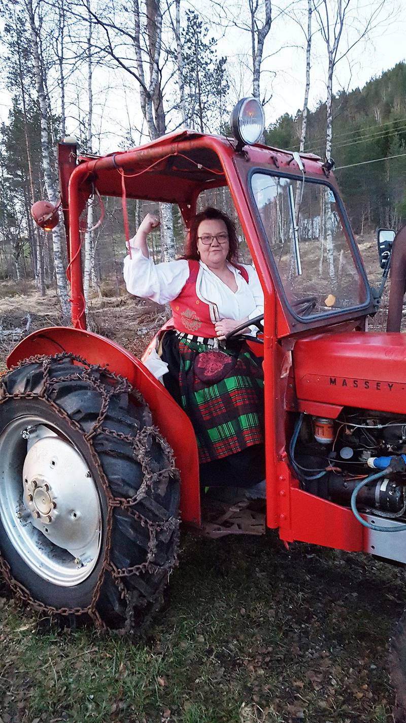 Bildet viser Ann Mari Korsrud med bunad. Hun sitter i en traktor. Korsrud kjemper for å beholde fødeavdelingen i Kristiansund.
