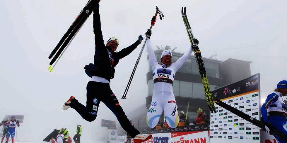 Bildet viser Charlotte Kalla og Ida Ingemarsdotter fra Sverige. De hopper av glede. Jentene tok gull i lagsprinten for kvinner i Holmenkollen onsdag.