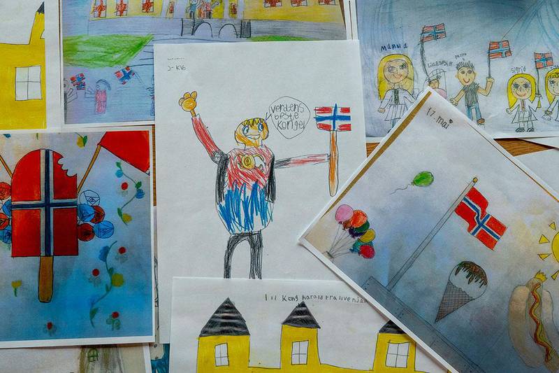 Bildet viser mange tegninger. Barn har tegnet det de forbinder med 17. mai. Kongeparet skal få alle tegningene på 17. mai. 