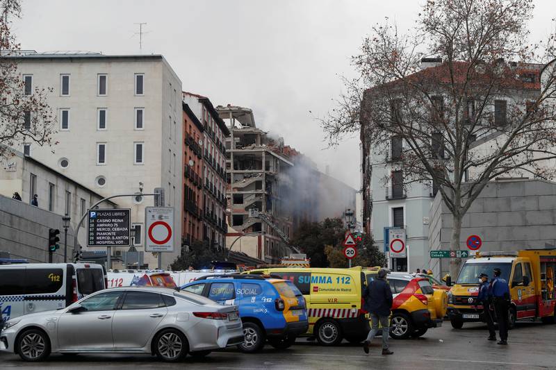Bildet er av en gate i Madrid. I bakgrunnen er røyk fra eksplosjonen i en bygning.