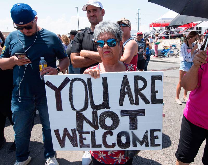 Bildet viser en kvinne som holder en plakat mot president Trump i El Paso i USA.