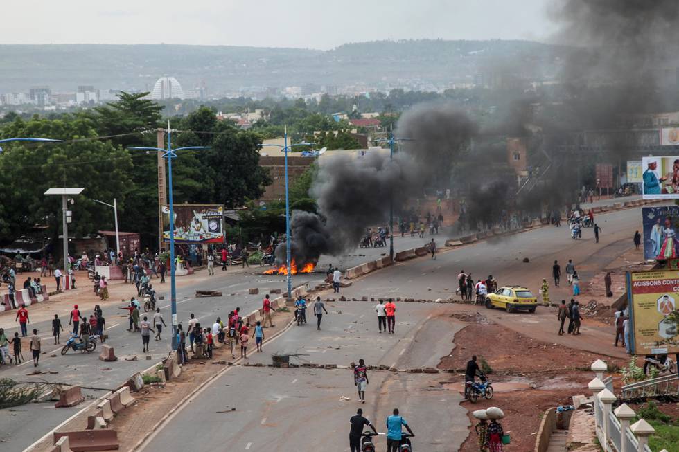 Bildet er fra forrige fredag. Da brente demonstranter blant annet bildekk i gatene i Bamako. Det er hovedstaden i Mali. Det er svart røyk på bildet, og mye folk i gatene. Det er bare en bil, og den står på en sidevei.