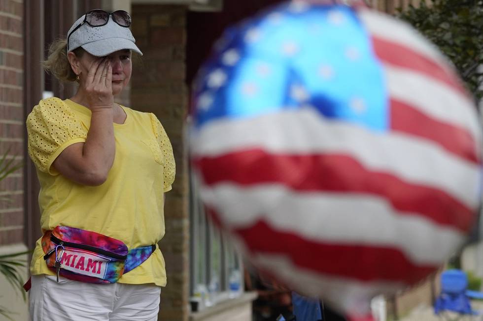 En kvinne tørker tårene etter skytingen mot en 4. juli-parade i Chicago-forstaden Highland Park mandag. Politiet leter etter en navngitt 22 år gammel mann. Foto: Nam Y. Huh / AP / NTB