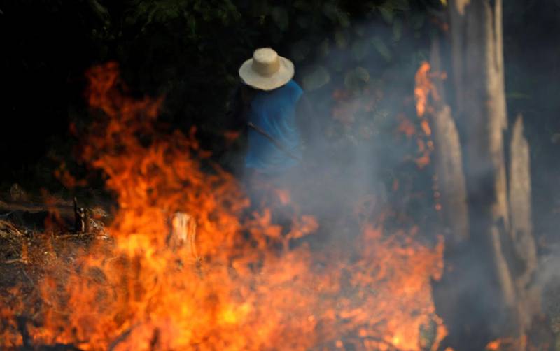 Bildet viser flammer og en person i nærheten.