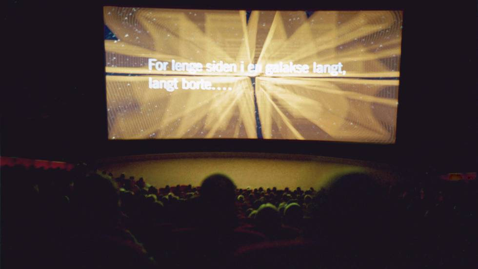 Bildet viser en kinosal og en film med tekst.