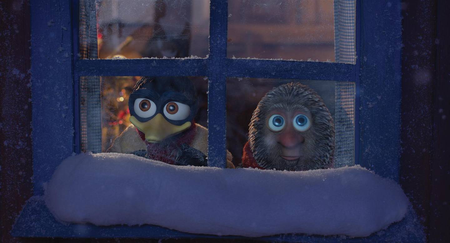 Bildet er av de to dukkefigurene Solan og Ludvig fra Flåklypa. De ser ut av et vindu. Det er snø på vinduskarmen.