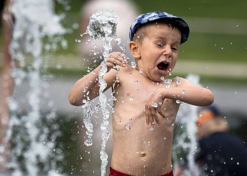 Bildet viser en gutt som leker i vannet i Vilnius i Litauen.