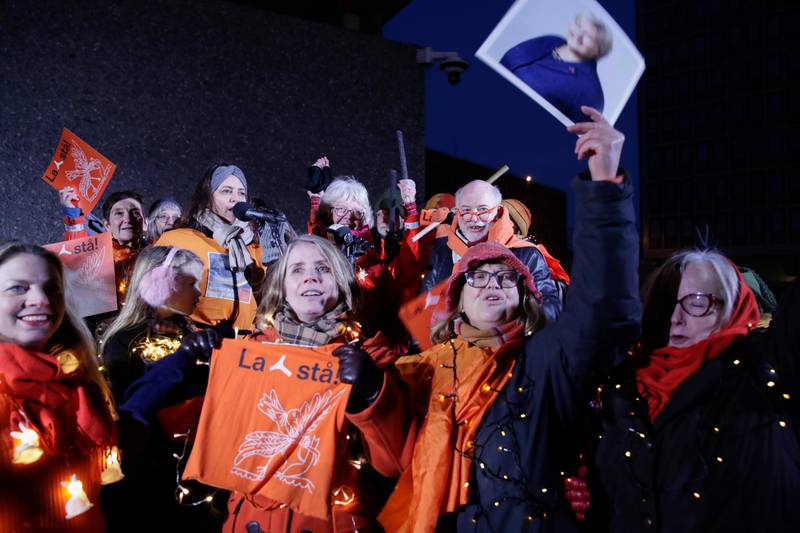 Demonstranter ikledd oransje tøy og lys