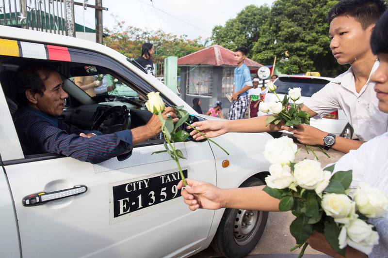 Bildet viser buddhister som deler ut hvite roser til muslimer i Myanmar.