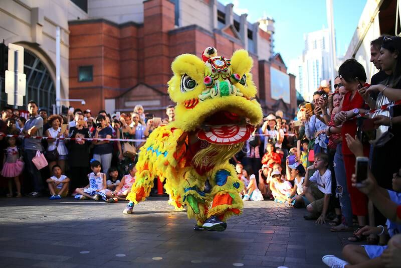 Australia: Dansere har kledd seg ut som en stor drage. De danser for å feire kinesisk nyttår. Mange har samlet seg for å se dragedansen. Feiringen skjer i Sydney i Australia. 