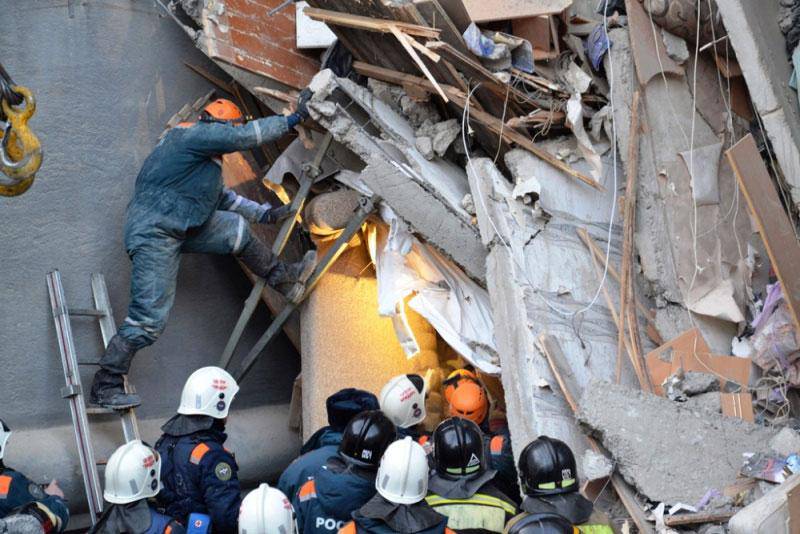 Bildet viser folk som leter etter overlevende i en ødelagt boligblokk.
