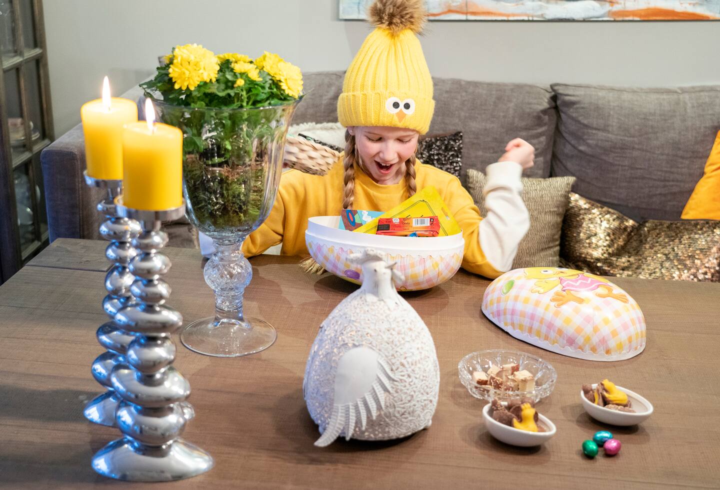 Bildet viser ei ung jente som ser ned i et påskeegg med godteri.