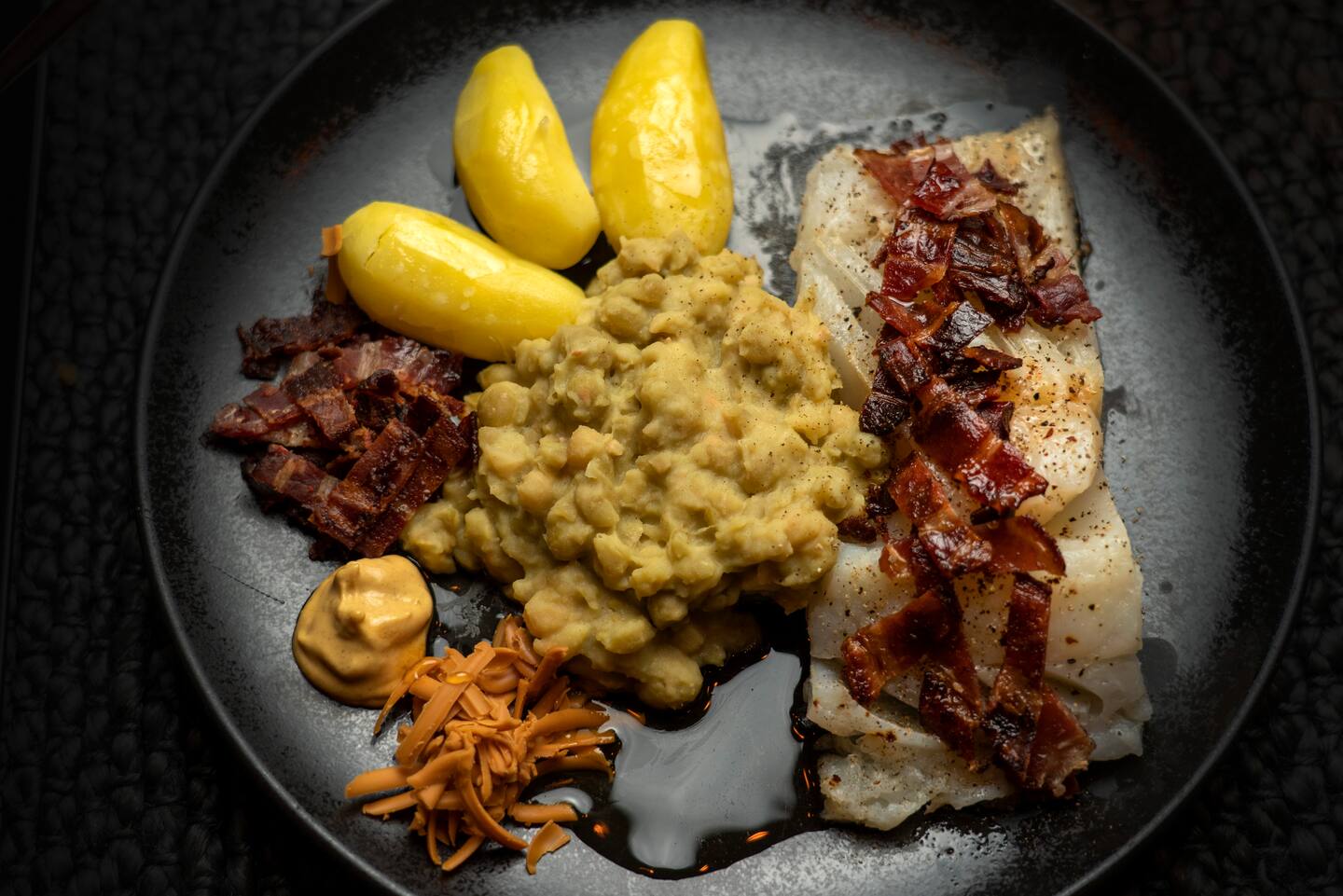 Bildet viser en tallerken med lutefisk med tilbehør.