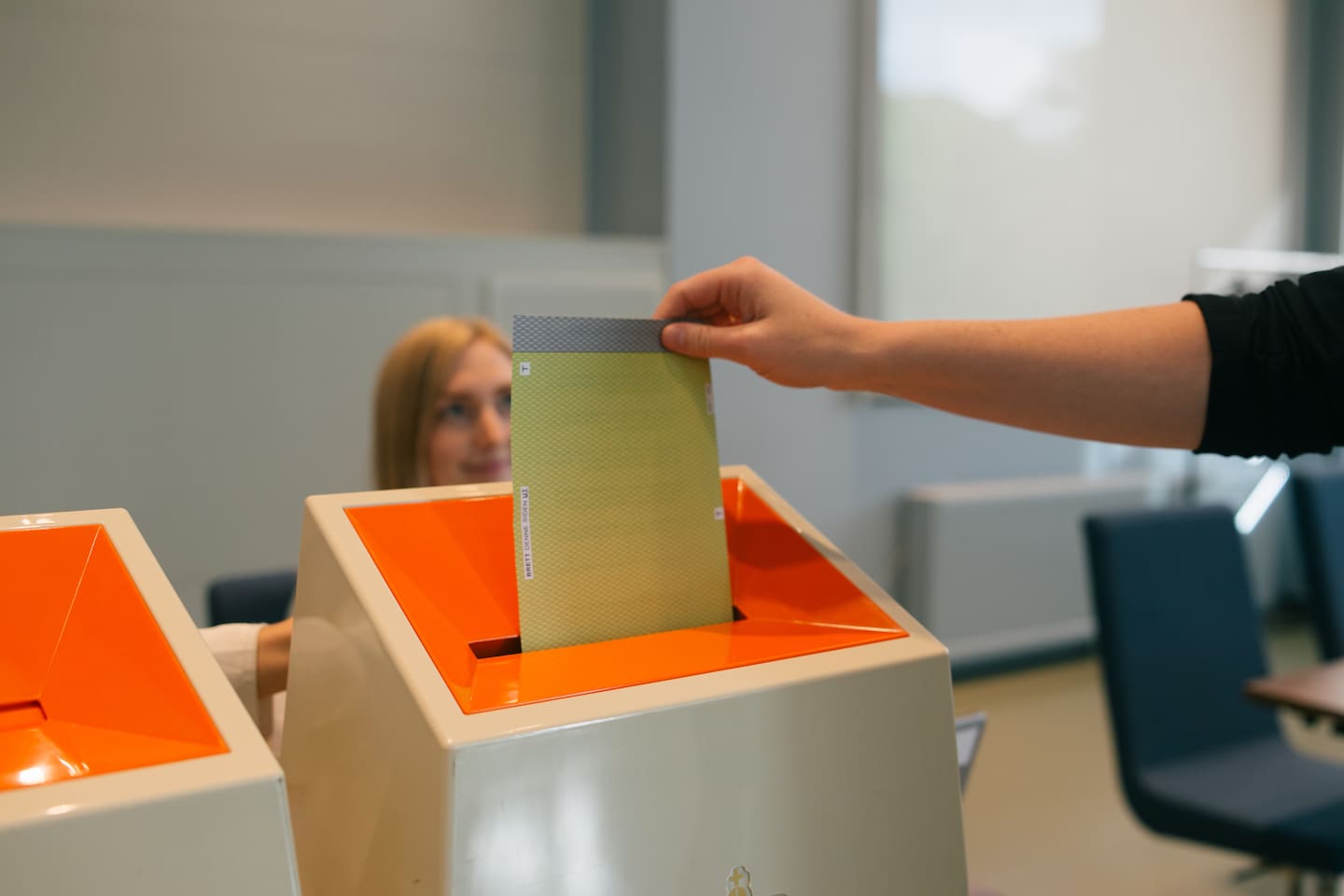 Bildet viser en person som putter en stemmeseddel i en valgurne.