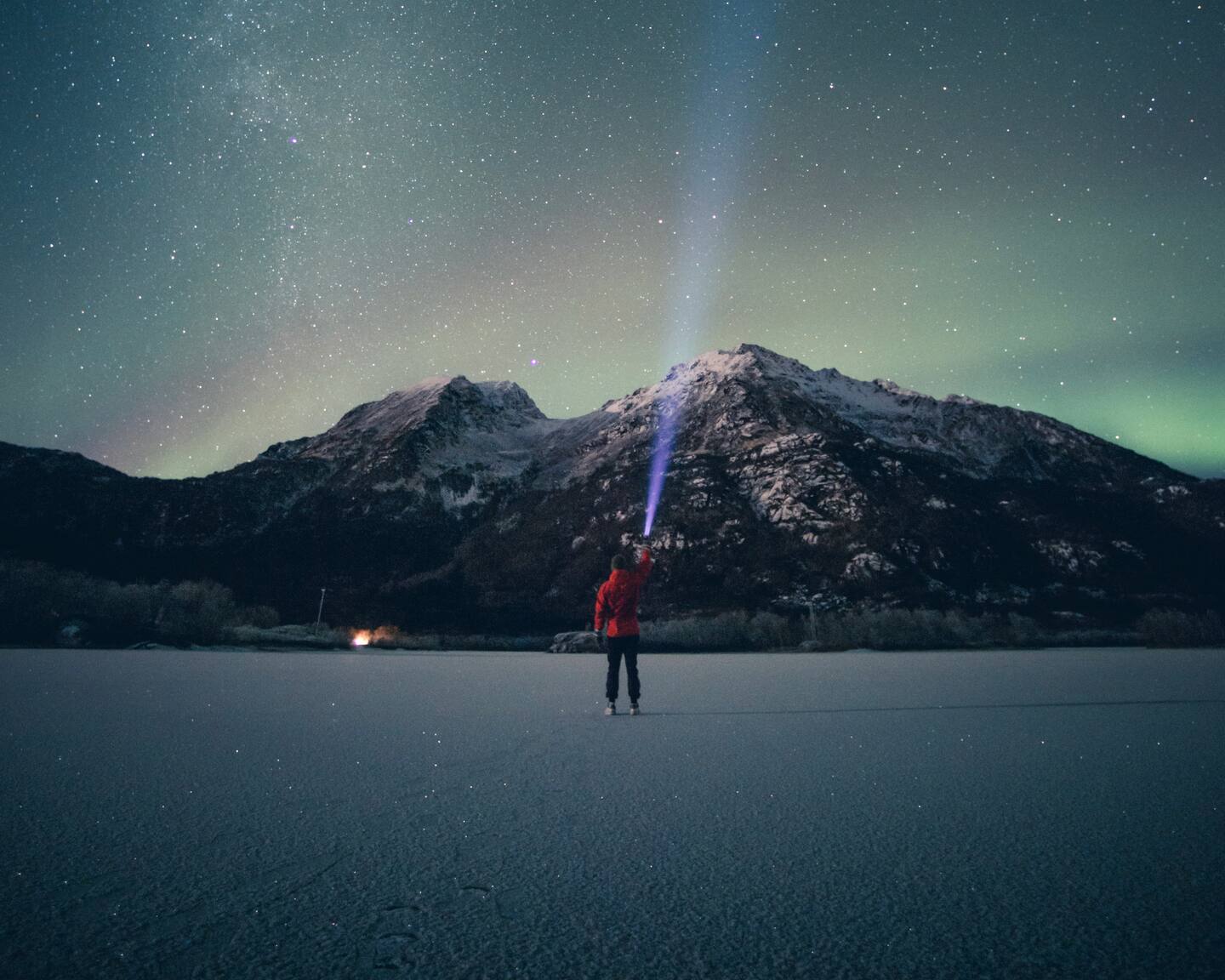 Bildet viser nordlys over fjellene Sørtind og Vågsfjellet ved Steinslandsvatnet i Hamarøy, Nordland.