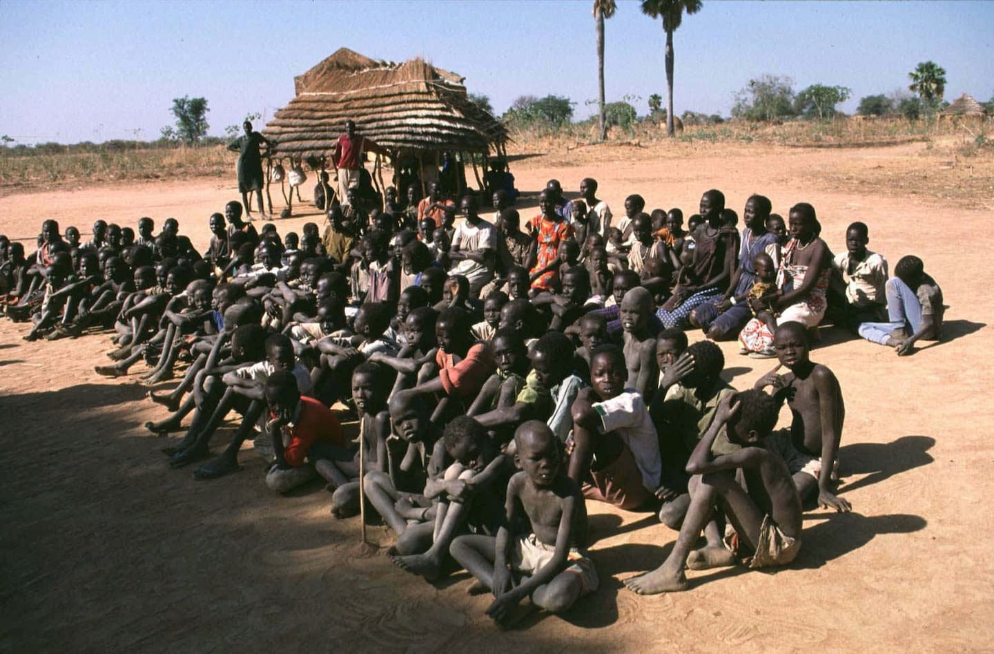 En gruppe kvinner og barn som tidligere har vært slaver venter på å bli frigjort. Bildet er fra Khartoum i 1997.