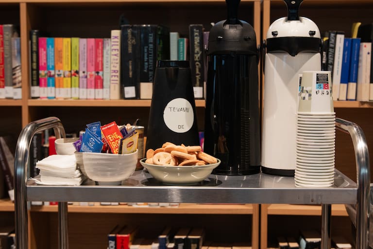 Bildet viser kaffe, te og kjeks på en tralle.