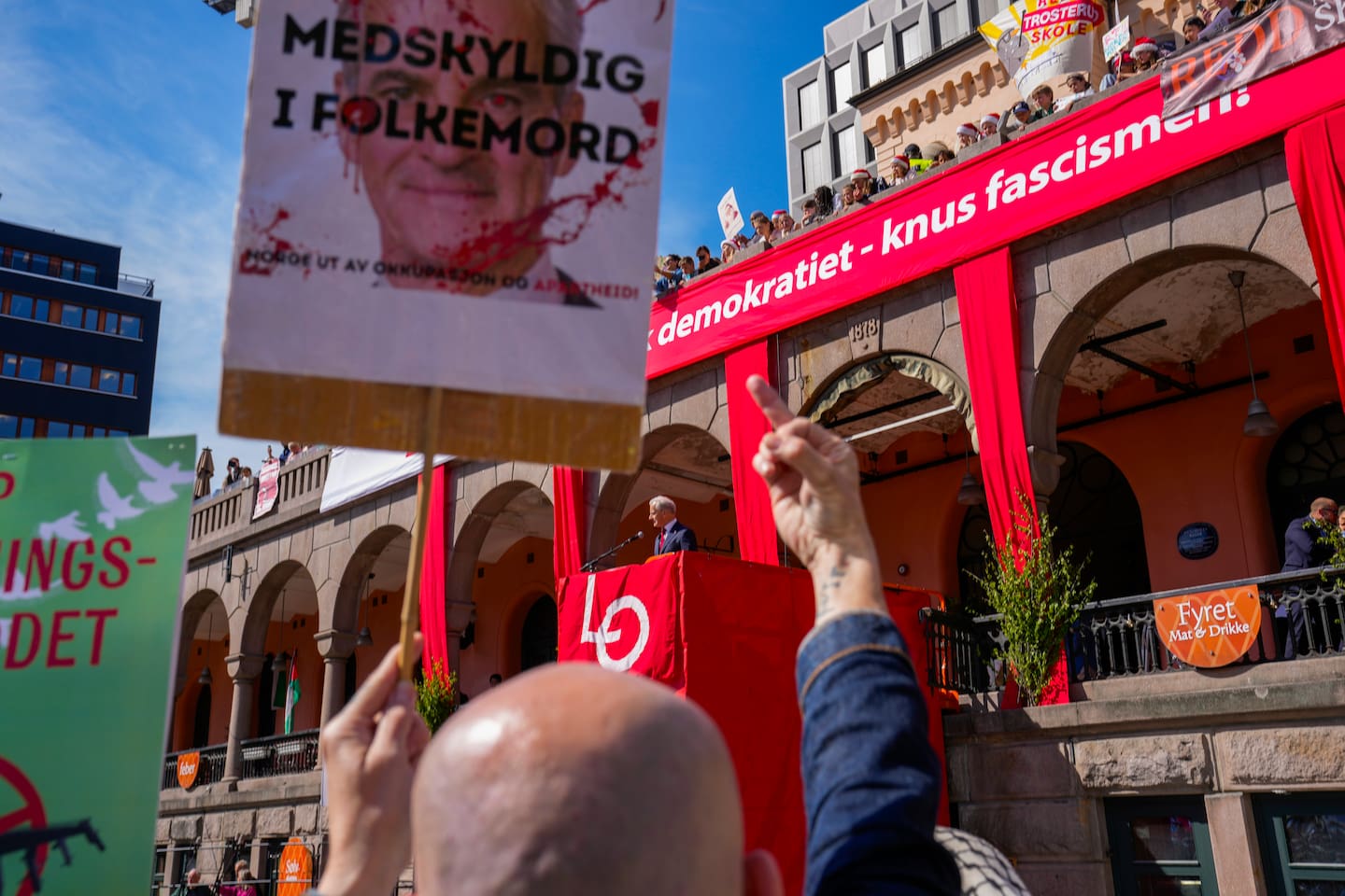 En demonstrant viser fingeren til statsministeren, som svarte demonstrantene med å hylle ytringsfriheten. Foto: Heiko Junge / NTB