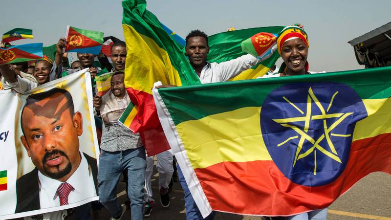 Bildet viser folk som jubler med flagg fra Eritrea og Etiopia.