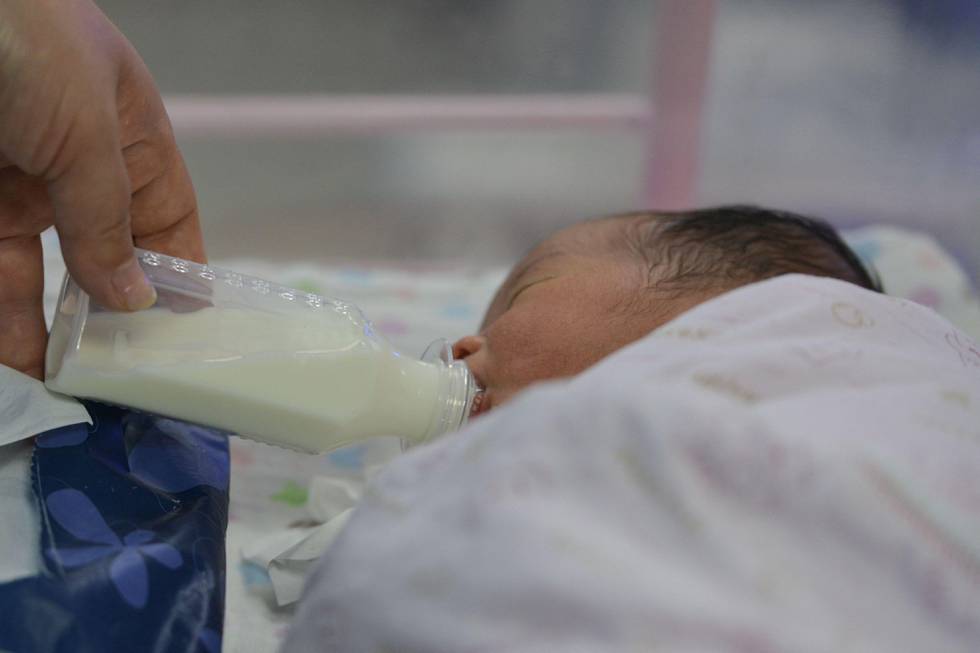 Bildet viser et nyfødt barn som blir matet med flaske.