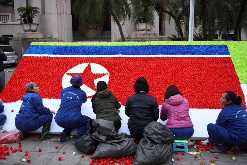 Bildet viser folk som laget et nordkoreansk flagg av papirblomster.