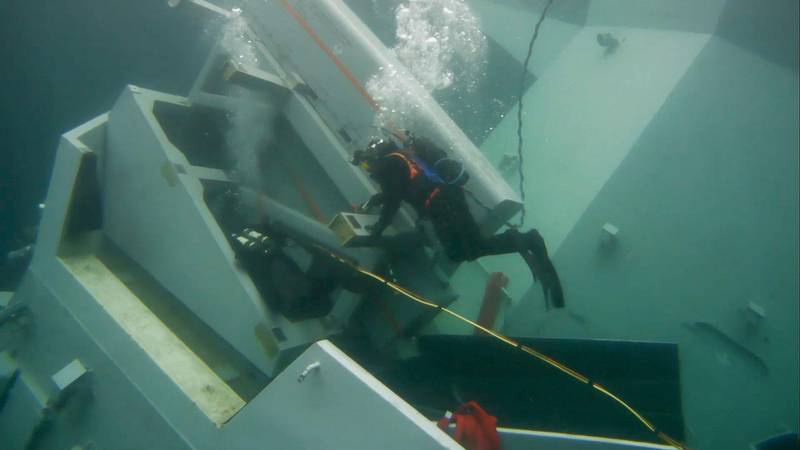 Bildet viser en dykker utenfor krigsskipet Helge Ingstad under vann.