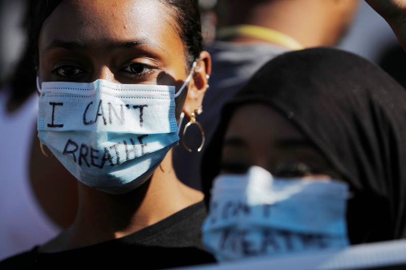 Bildet viser en kvinne med munnbind, der det står skrevet "jeg får ikke puste".