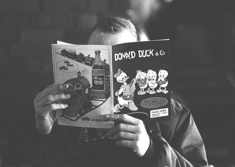 Bildet viser en mann som leser Donald-blad for mange år siden. Før leste «alle» Donald Duck. Nå er det ikke lenge før det er slutt for bladet, tror tegneserie-ekspert. 