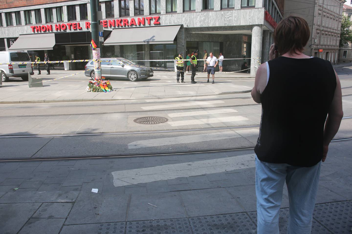 Bildet viser Elin Stillingen. Hun står på andre siden av Rosenkrantz gate, der det er lagt ned blomster. Noen politifolk står like ved politisperringene.
