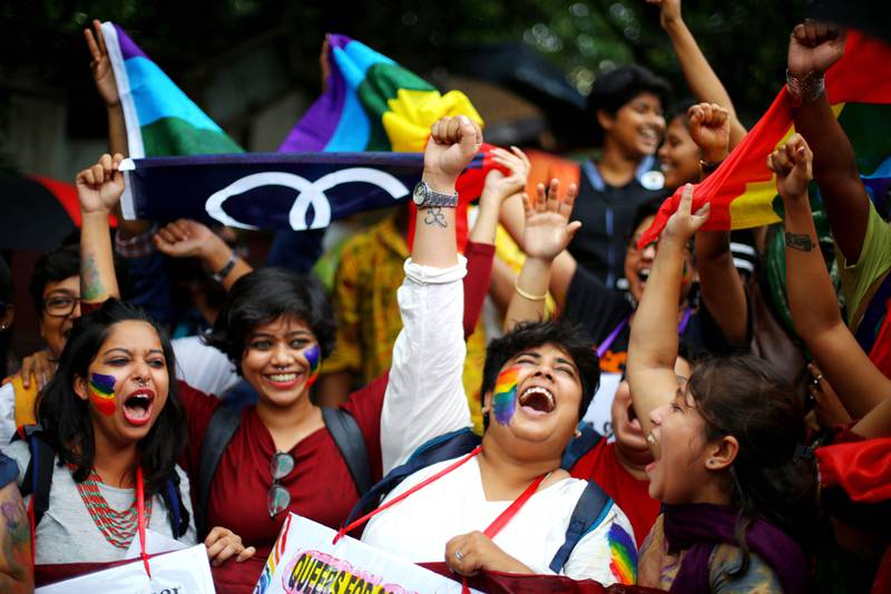 Bildet viser indere med regnbueflagg og ansiktsmaling som jubler.