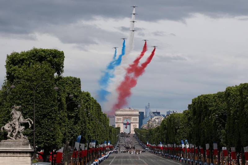 Bildet viser feiringen av nasjonaldagen i Paris. Gatene er pyntet med flagg og jetfly flyr over himmelen med de franske fargene.