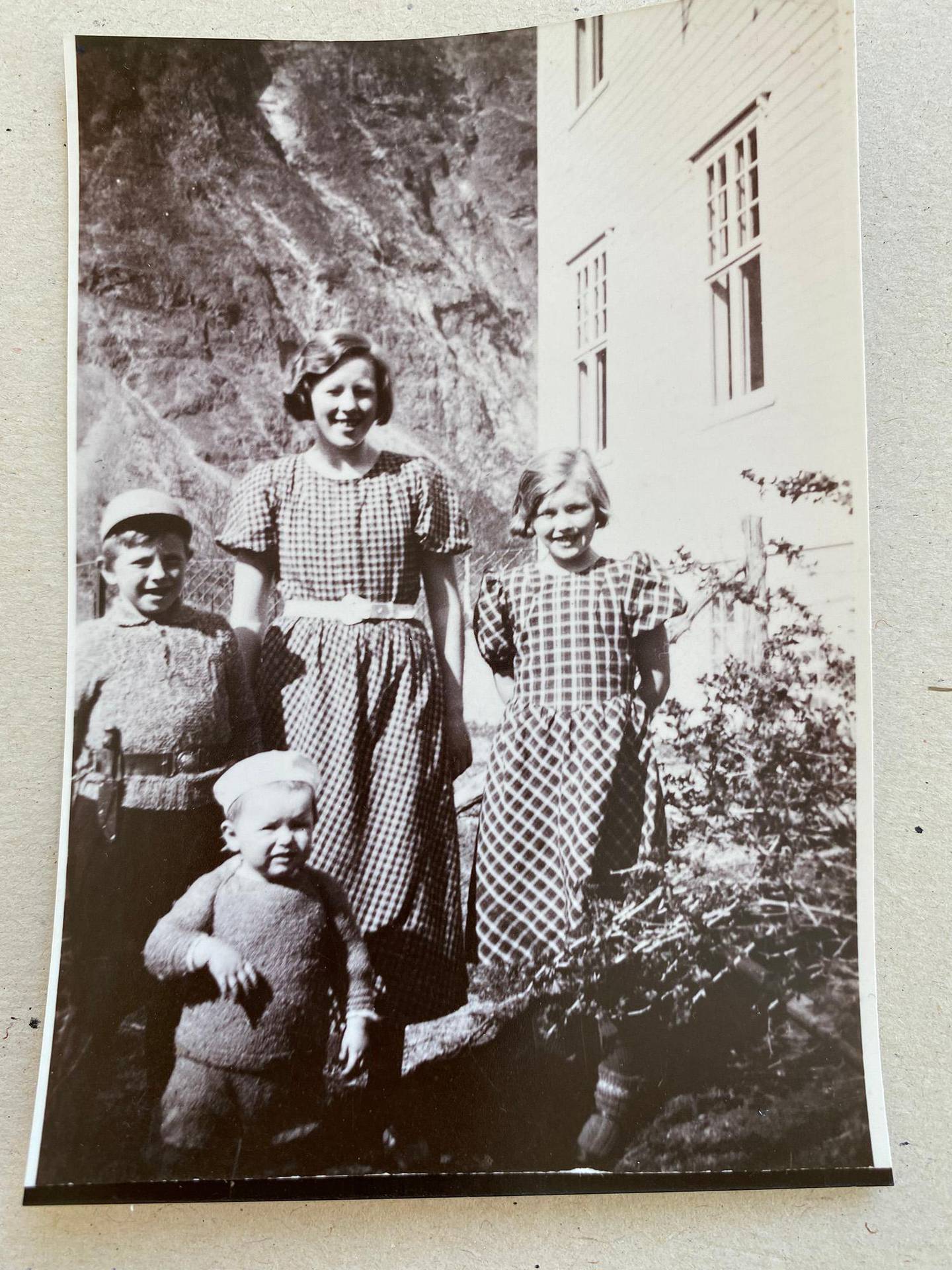 Bildet viser fire barn foran et hus.