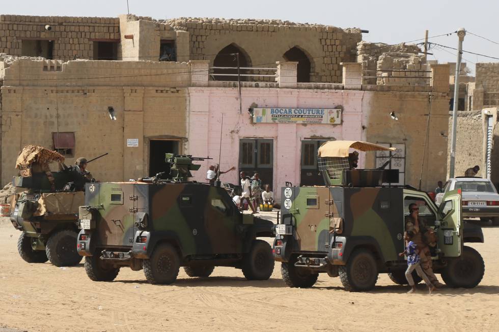 Bildet er av franske soldater i biler. De er ute på patrulje i Timbuktu i Mali. Bilene står på en åpen plass foran murbygg. Det er sand på bakken. Foto: Moulaye Sayah / AP / NTB