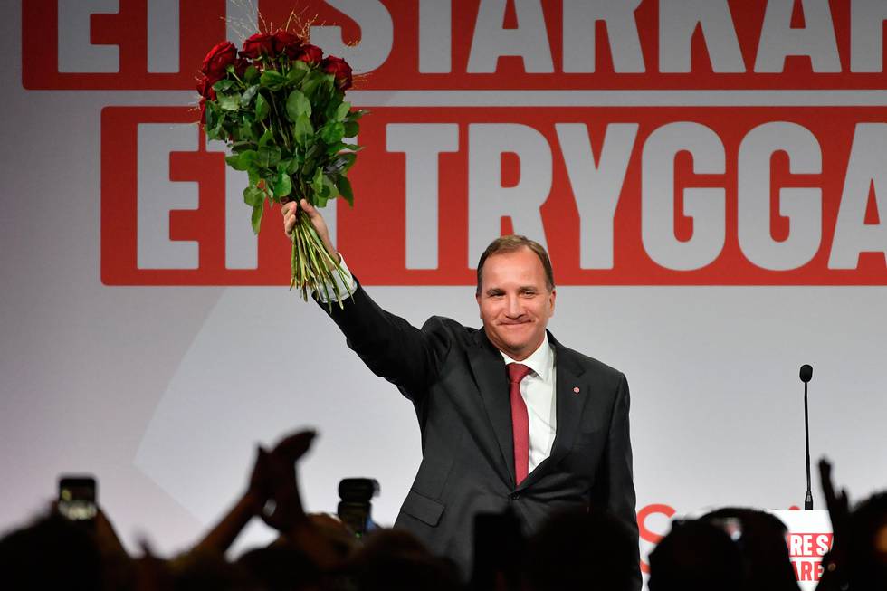 Bildet viser statsminister Stefan Löfven som holder opp blomstrer.