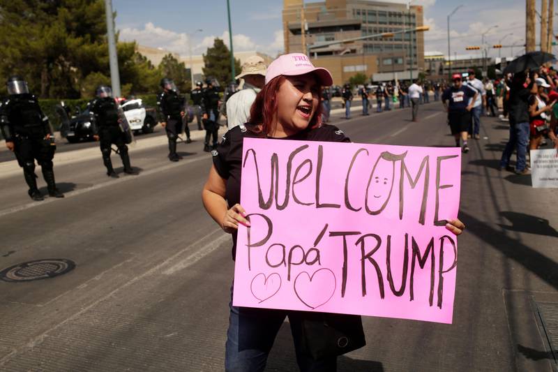 Bildet viser en kvinne som holder en plakat til støtte for Trump i El Paso.